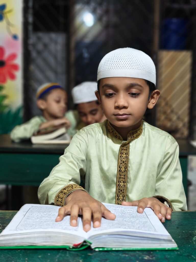Young boy reading Quran in a classroom setting